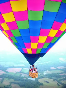 A colorful hot air balloon with people inside.